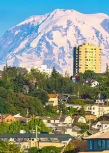 A picturesque view of a city with a snow-capped mountain